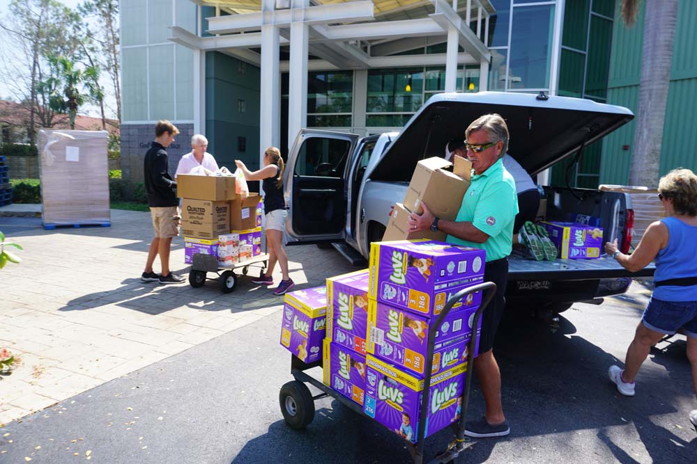 people loading diapers into car for donating
